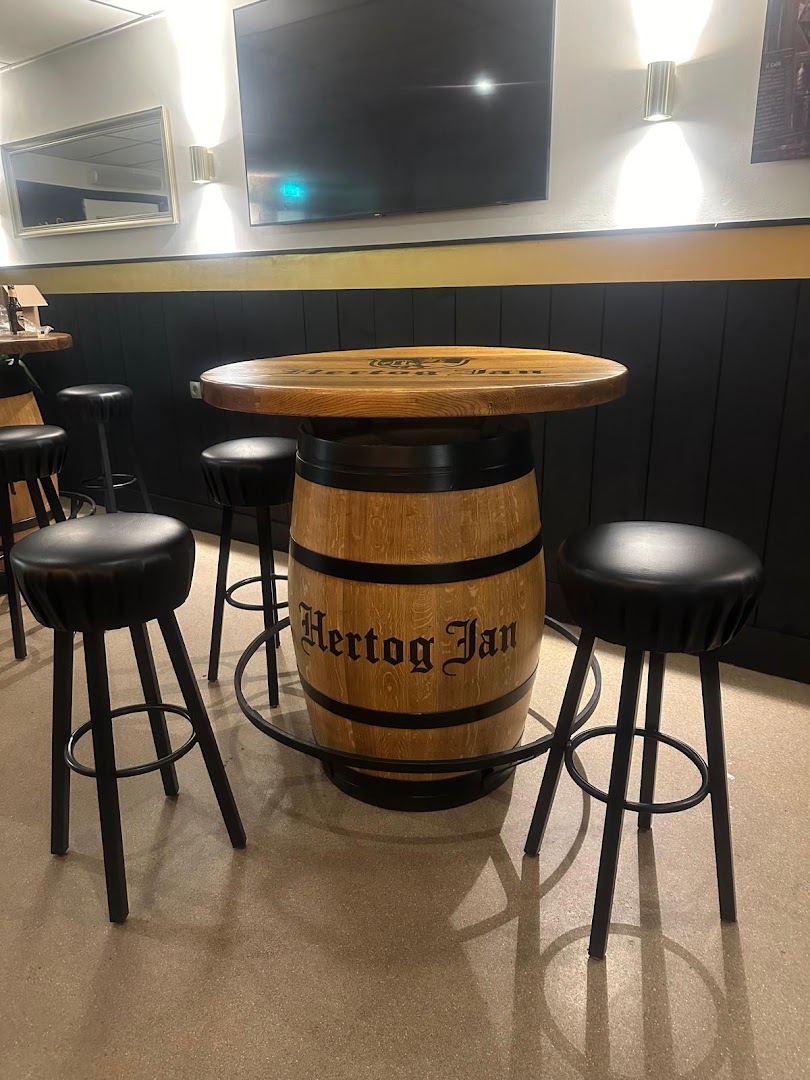 Statafel gemaakt van een Hertog Jan-whiskeyvat met krukjes in Café de Klundert